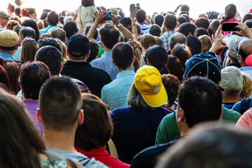 Group of spectators with a man with a yellow cap at center