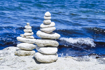Stack of round white stones standing on the shore of a sea