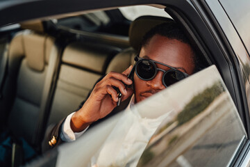 Joyful businessman of african descent with phone