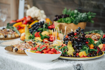 Abandant table set for an event. Large plates full of fruit.