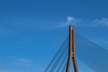Fototapeta na wymiar View of the blue sky and cable-stayed bridge supports and ropes