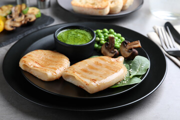 Grilled squid tubes served on grey table