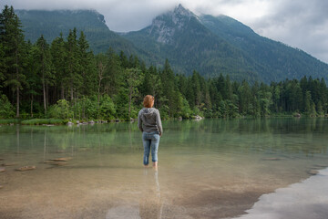 Young woman taking a break at the lake close to the mountains