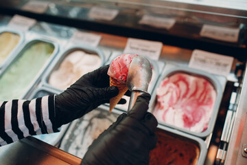ice cream maker lays multicolored ice cream cup.