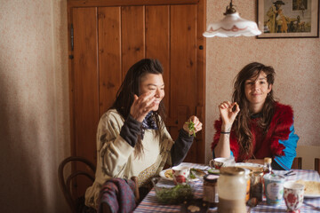 queer female couple in colourful clothes eat breakfast  Czech cottage