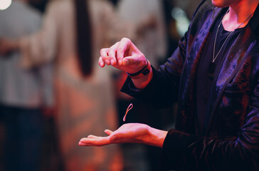 close up view of magician hand showing focus with flying object rubber band on a hair.