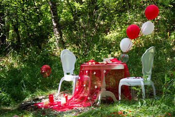 Autumn evening photo shoot - romantic dinner outdoors. Table with tablecloth and decoration - pie, figs, glasses, plates, table and balloon