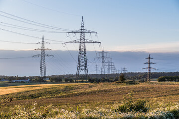 Strommasten einer &Uuml;berlandleitung bei Sonnenuntergang