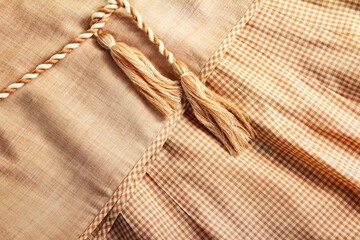 Close-up photo of linen cloth dress texture with lacing, edgiing and ruffle elemets.