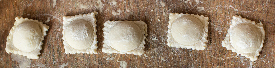 stuffed ravioli raw dough and filling square dumplings on the table, healthy food meal snack copy space food background rustic. top view