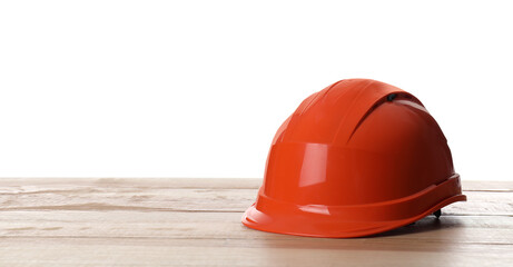 Orange hard hat on wooden table against white background. Space for text