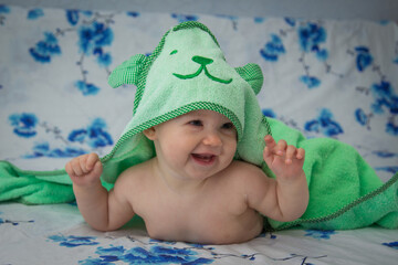Little baby wrapped in a green towel after a shower