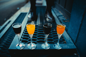 Elegant glass with multi-colored liquor or shot with tincture Colored bokeh Industrial background