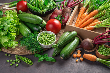 Fresh, juicy vegetables and herbs on a brown background. Side view, horizontal.