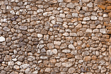 Stone wall background. Old weathered castle stone wall texture. Stones and rocks of different shapes