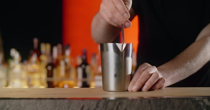 Barman slowly stirs mixed cocktail in the shaker on the bar counter, refreshment alcohol drink at the nightclub, 4k Prores HQ 120fps