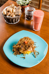Brazilian Cuscuz Yellow Couscous Corn Flour Flakes With Jerk Beef Steak on a blue plate