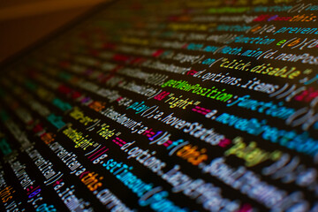 Programming code on background computer screen for website, app and software development written in JAVASCRIPT and HTML in closeup view