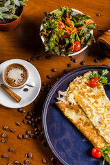 Perfect Breakfast Tapioca Toasted Cheese on a blue plate with Coffee Cinnamon and Salad over a Wooden Table with Coffee Beans