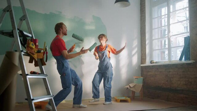 Active family singing with rollers during house renovation in new apartment.