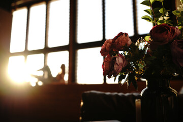 Beatiful artificial flowers with blurred posing girl model