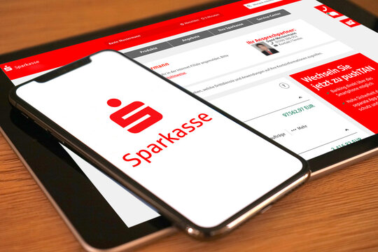 Smartphone mit Sparkassen Logo liegt auf einem Tablet welches die Kontoübersicht im Online-Banking anzeigt, Digitalisierung, 2022
