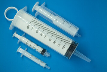 medical disposable syringes of different volumes on a blue background.