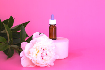 Obraz na płótnie Canvas Composition of dark glass with cosmetic, medical products. Bottles with allergy medicine or serum, oils on catwalks with white peony on pink background.