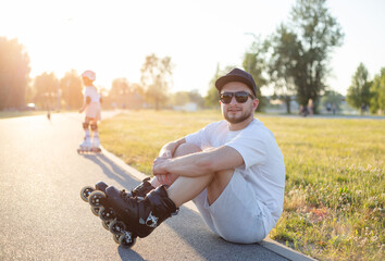 Portrait of a guy in roller skates sitting on ground. sports concept.