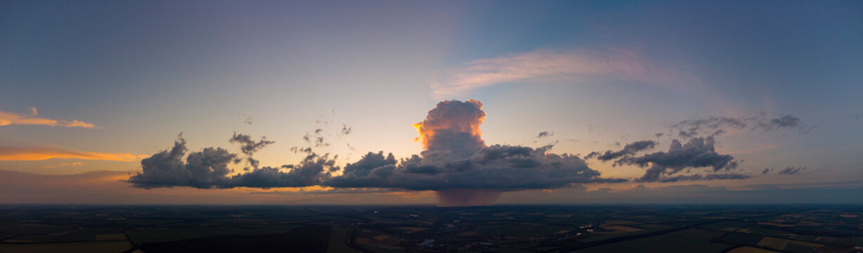 Storm cloud with rain at sunset