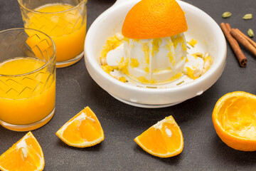 Chopped oranges on table. Two glasses of orange juice.