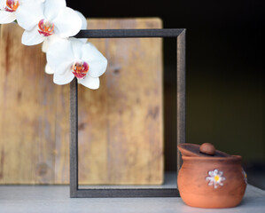 Part of an empty black frame on a wooden rustic background, part on a distant dark background with...