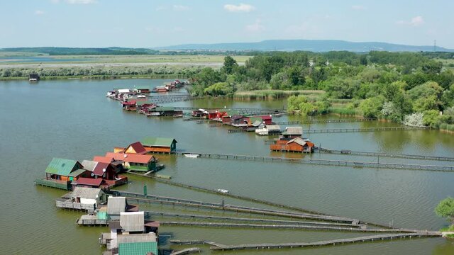 Aerial view of the famous Bokod Floating Village with piers and traditional wooden fishing cottages built on the lake Bokodi. Walkboards leading to small fishing houses floating on water in Oroszl&aacute;ny