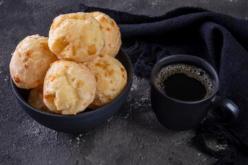 delicious cheese breads and a coffee mug on dark background