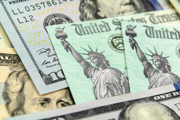 Macro view of the Statue of Liberty on a United States Treasury Checks with currency in background