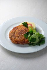 Menu for the restaurant: Cordon bleu with potatoes, lettuce, cherry tomato and lemon.