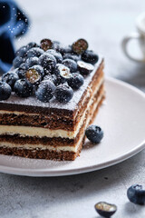 Morning breakfast with coffee and cake. Piece of cake on a plate decorated with fresh blueberries