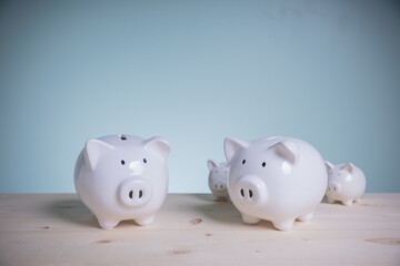 Family white piggy bank on old wood looking at green background. Father and mother little piggyback training save money for growth in the future. Concept family saving money for the future.