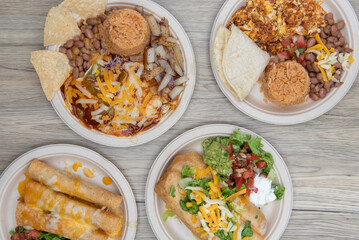 Mexican food feast consisting of a chimichanga, chicken taquitos, chorizo and eggs, and huevos ranchers for a choice between breakfast and lunch