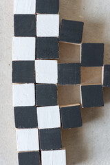 black and white hand painted wood craft cubes arranged on a millboard background - photographed...