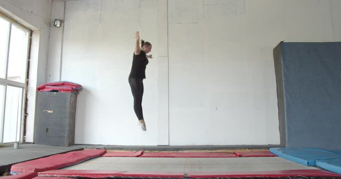 Gymnastics on a trampoline, woman is jumping high and doing flips, sports, 4k