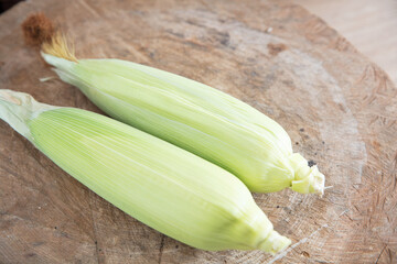 Fresh corn on the cob on a cutting board