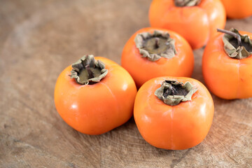 Autumn ripe red persimmons on cutting board
