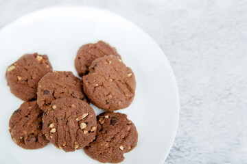 A vertical top view of delicious chocolate chips cookies on a white plate