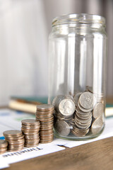 Big glass bottle piggy bank and coins