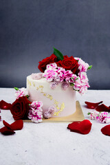 Beautiful Wedding cake with flowers on table and black background.