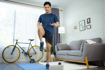 Fototapeta na wymiar Young man exercising at home. He was running in the living room.