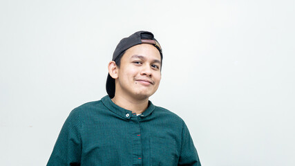 A portrait of young Asian Malay with black cap and casual green shirt smiling at the camera...