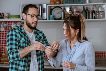 Pareja de jóvenes tienen un momento de relax en la cocina mientras preparan la cena para disfrutar junto a amigos