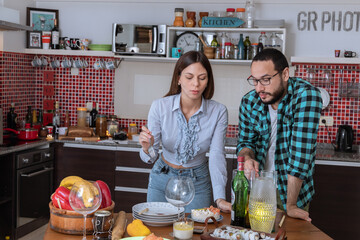 Pareja de jóvenes sirviendo el sushi en la cocina esperando amigos a cenar  